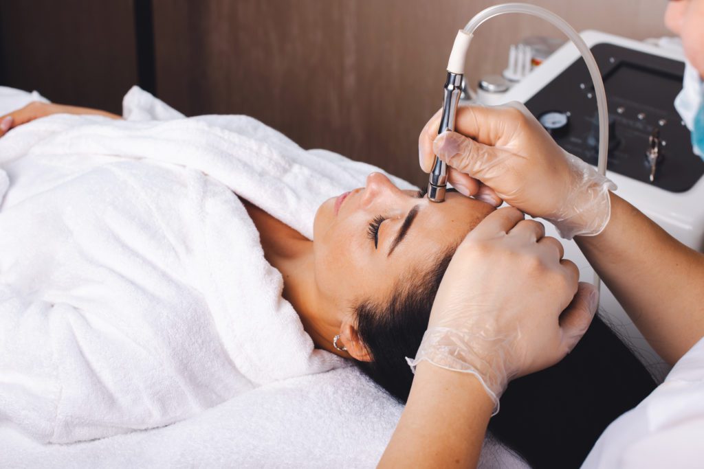 Woman getting Dermabrasion on her face with a specialist