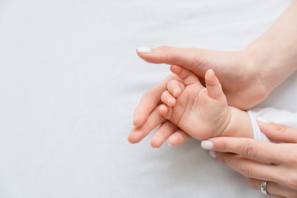 Woman holding a baby hand in her hand