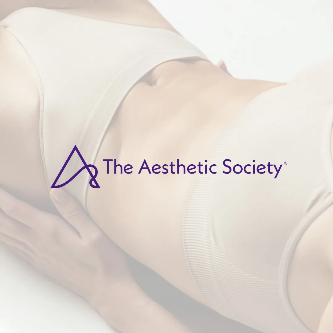 Close-up of a person in light-colored undergarments, showcasing their midsection with hands resting on hips. The logo and text The Aesthetic Society overlay the image, hinting at the most popular treatments in body aesthetics.