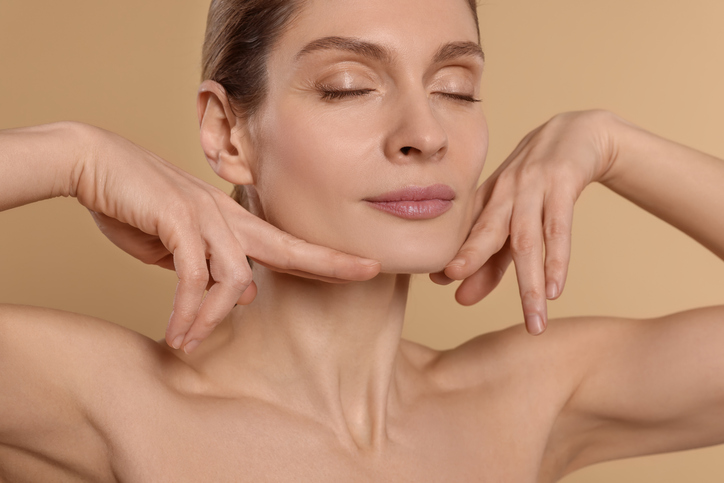 Woman showing how a facelift Toronto and neck lift tighten the jawline and neck.